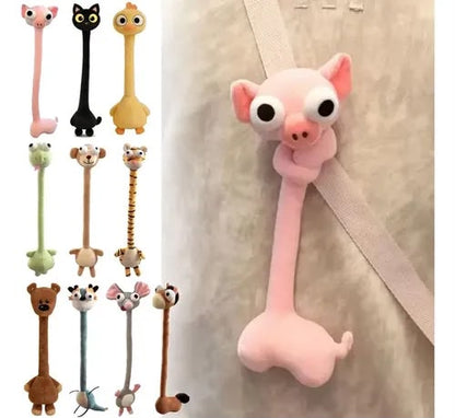 A pink pig-shaped hanging hook with a long neck and large eyes, shown attached to a beige strap on a light wall. Smaller thumbnails along the left show additional animal hook designs in pink, black, yellow, green, tan, brown, and blue.