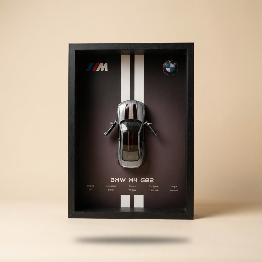 BMW M4 3D Framed Diecast Wall Art in a 32cm x 23cm black shadow box frame, featuring a grey 1:32 scale model car with open doors against an M-Power design background with performance stats.